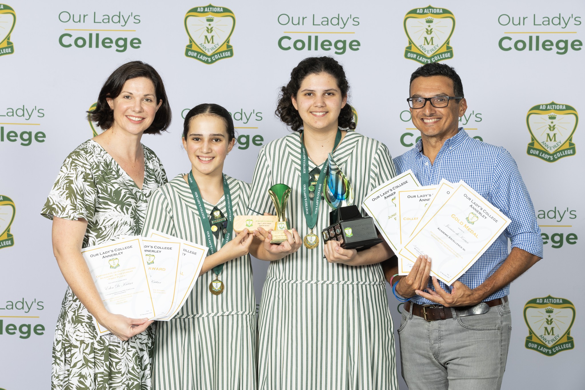 two students with their parents celebrating their achievements