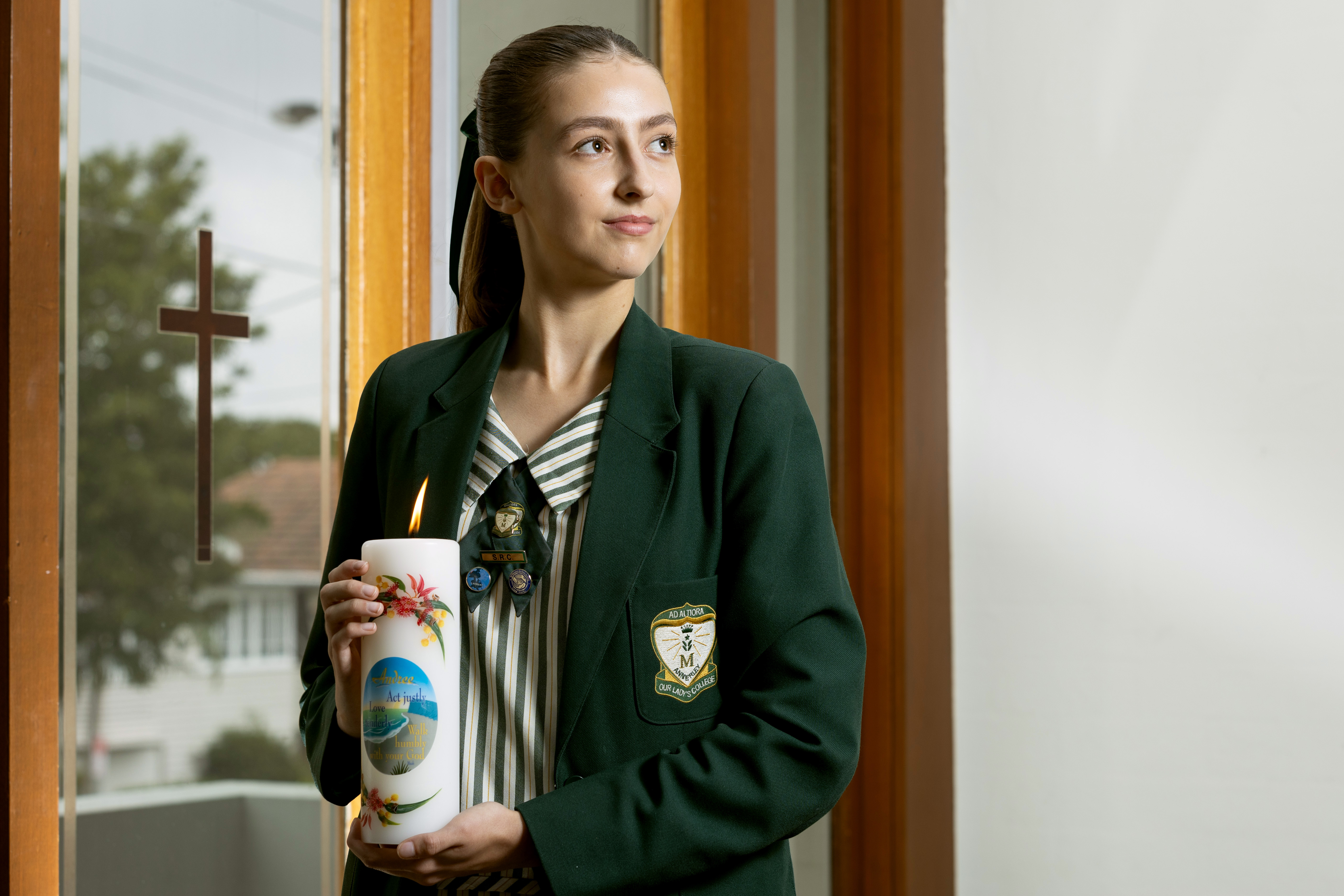 girl holding a candle and looking away from the camera
