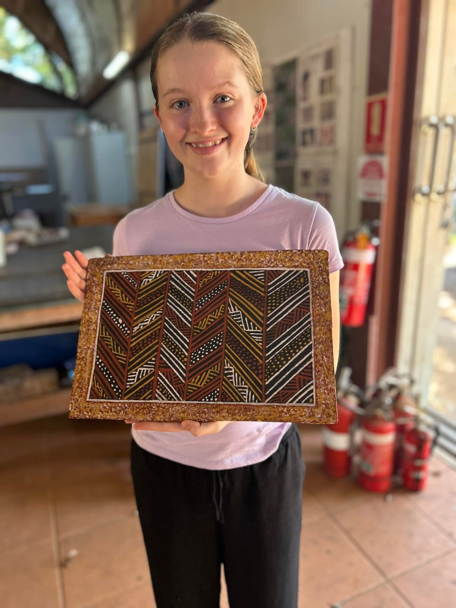 Student displaying a handmade artwork during a cultural or creative learning activity.