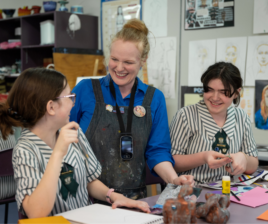 teacher working with two students in the art room
